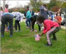 ?? KEVIN TUSTIN - DIGITAL FIRST MEDIA ?? Students get to planting American flags into the lawn of Primos Elementary. This was a notion to honor veterans ahead of Veterans Day on Sunday.