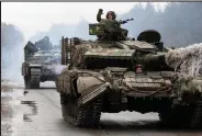  ?? Anatolii Stepanov / Getty Images ?? Ukrainian servicemen ride on tanks towards the front line with Russian forces in the Lugansk region of Ukraine on Friday.