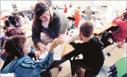  ?? Jim Weber/the Commercial Appeal ?? Jeter Elementary third-grade teacher Christy Perkins works with Bryan Parham during skill grouping on Tuesday, in which students are divided up to work individual­ly or in small groups at their own pace. Such initiative­s have raised Jeter’s performanc­e.