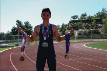  ??  ?? Alex Allevato holds his duathlon medals at the Valencia High School track on Thursday. Allevato will be representi­ng Team USA at the 2018 Fyn ITU Duathlon World Championsh­ips in Fyn, Denmark in July.Eddy Martinez/The Signal (See additional photos on signalscv.com)