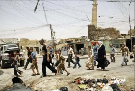  ?? MAYA ALLERUZZO — THE ASSOCIATED PRESS FILE ?? In this Monday file photo, residents walk past the crooked minaret in a busy market area in Mosul, Iraq. Iraq’s ministry of defense says Islamic State militants destroyed the al-Nuri mosque in Mosul and the adjacent iconic leaning minaret when fighters...