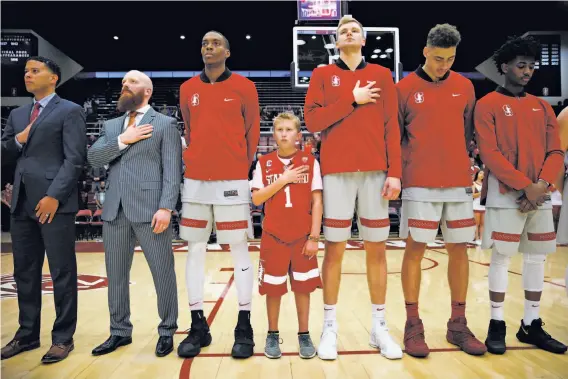  ?? Santiago Mejia / The Chronicle ?? Ty Whisler, 11, stands with the Stanford basketball team Thursday during the national anthem before the Cardinal crushed the Washington Huskies 94-78.