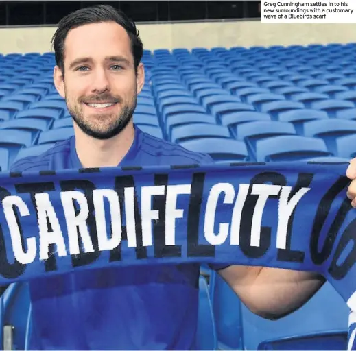 ??  ?? Greg Cunningham settles in to his new surroundin­gs with a customary wave of a Bluebirds scarf