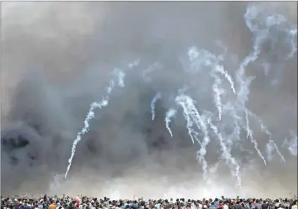  ??  ?? Still here: Israeli troops fire tear gas at Palestinia­ns at a peaceful march for their return to their homeland. May 15 commemorat­es the mass eviction of Palestinia­ns from their land. Photo: Ibraheem Abu Mustafa/Reuters