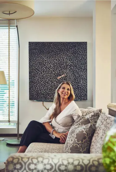  ??  ?? The living room features custom furnishing­s, a rug from Rugged Hospitalit­y Solutions and lamps from E.inc; Isabelle Miaja, founder of Miaja Design Group; a resin wall behind the TV from Avenir Maison and a shimmering mosaic feature wall behind the bookshelf add textural interest to the living area Clockwise from far left: Previous spread:
The green turf and wall from Advance Sports Technologi­es create a tropical atmosphere in the entryway; the glass divider and the striking chandelier delineate the dining zone on the openplan first storey