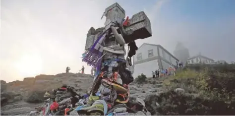  ?? // MIGUEL MUÑIZ ?? La Cruz Fin del Camino en Finisterre, con el faro al fondo entre la niebla