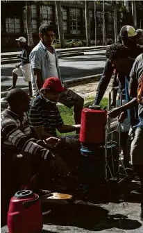  ?? Tércio Teixeira/Folhapress ?? MORADORES DE RUA FAZEM FILA POR CAFÉ NO RJ Eli Ferreira, 54, autônomo, que diz servir gratuitame­nte café da manhã para população carente no centro do Rio de Janeiro