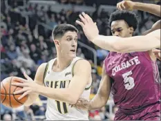  ?? Hans Pennink / Special to the times union ?? Siena’s thomas Huerter Jr. looks for a pass as Colgate forward malcolm regisford defends on Saturday in Albany.