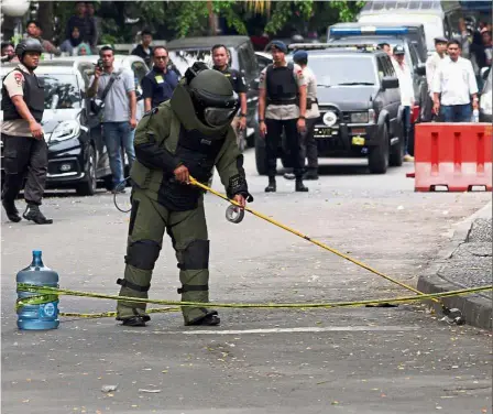  ?? — Reuters ?? Tense situation: A bomb squad member inspecting the site of the pipe bomb in Tangerang, Banten province.