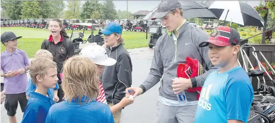  ?? WAYNE CUDDINGTON ?? Kyle Turris signs autographs at a charity golf tournament. The player and his family were known for their many personal contributi­ons to the community.