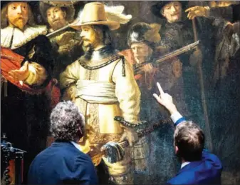  ?? FREEK VAN DEN BERGH/ANP/AFP ?? Restorers look at Rembrandt van Rijn’s world-famous masterpiec­e Amsterdam, on July 8. (1642) in