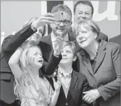  ?? Daniel Mauerer
European Pressphoto Agency ?? ANGELA MERKEL, right, poses with two of her party’s candidates and others a day before the vote.