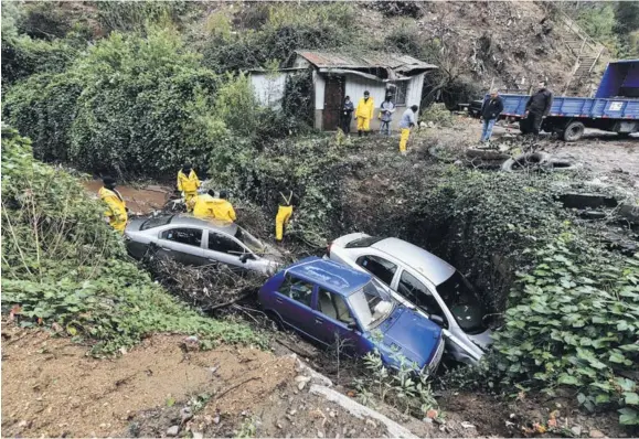  ??  ?? Tres vehículos cayeron al tranque Los Pascuales debido al debilitami­ento del terreno en el sector de Rocuant.