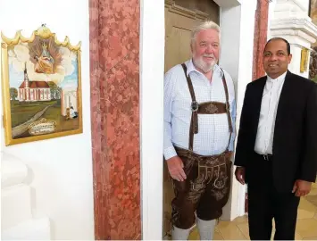  ?? Foto: Gisela Klöck ?? Franz Berger (links) und Pater Joaquim in der Wallfahrts­kirche in Vilgertsho­fen neben der Votivtafel von Pfarrer Anton Hofmiller. Die tiefe Gläubigkei­t beeindruck­te Berger so sehr, dass er bis heute für die Kirche aktiv ist.