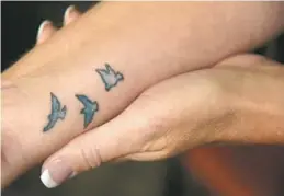  ??  ?? Radio personalit­y Maria Dennis had these three birds outlined in blue tattooed on her wrist after her cancer went into remission. They are symbols of “flying high and being free of this awful disease,” she says.