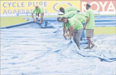  ??  ?? Ground-staff engage in mop-up operations during last Friday’s rain-affected opening ODI.