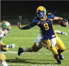  ??  ?? Brawley Union High’s Casey Kline gives a stiff arm as he runs the ball against Yuma Catholic High during a non-conference football game on Friday in Calipatria. SERGIO BASTIDAS PHOTO