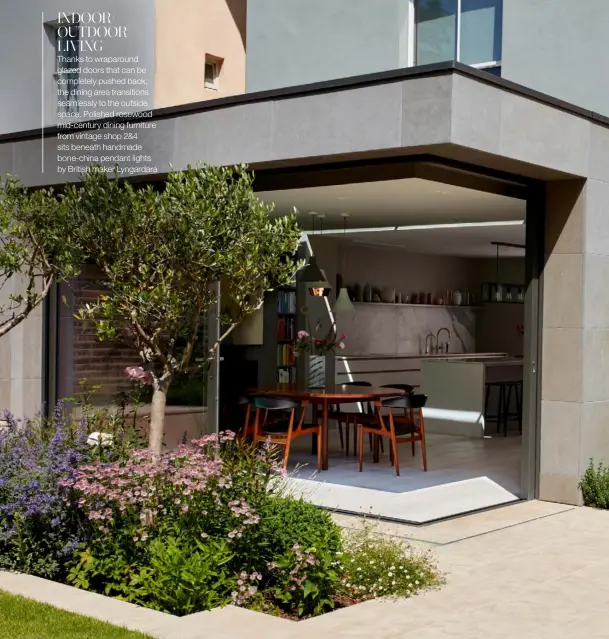  ??  ?? INDOOR/ OUTDOOR LIVING
Thanks to wraparound glazed doors that can be completely pushed back, the dining area transition­s seamlessly to the outside space. Polished rosewood mid-century dining furniture from vintage shop 2&4 sits beneath handmade bone-china pendant lights by British maker Lyngardara