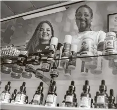  ?? Mark Mulligan / Staff photograph­er ?? Manager Caroline Mallon and Ron Fleming work at Sacred Leaf, a store that specialize­s in CBD, in Katy.