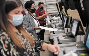  ?? JOE RAEDLE GETTY IMAGES ?? Workers test voting machines at the Miami-Dade Election Department headquarte­rs on Wednesday, when President Donald Trump gave a virtual address to the state’s economic club.