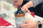  ?? AP ?? Researcher­s at Space Cargo Unlimited prepare a bottle of red wine that was later flown to the Internatio­nal Space Station.