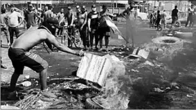  ??  ?? Demonstrat­ors burn tires during a curfew in Baghdad. (Photo: Al Jazeera)