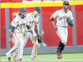  ?? JOHN BAZEMORE — THE ASSOCIATED PRESS ?? Giants outfielder­s, from left to right, Allen Hanson, Gorkys Hernandez and Andrew McCutchen run in after the final out of Saturday’s 11-2 rout of the Atlanta Braves.
