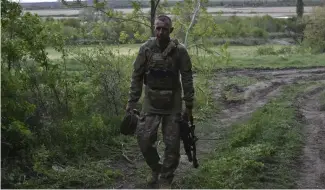  ?? ?? A Ukrainian serviceman with the 65th Brigade walks to his armored vehicle at the frontline in Zaporizhzh­ia region, Ukraine, Sunday, April 21, 2024.