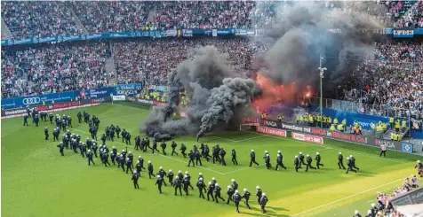 ?? Foto: Nordphoto, Kokenge ?? Mit einem Großaufgeb­ot hat die Hamburger Polizei wohl einen Platzsturm einiger HSV Ultras verhindert. Nach dem feststehen­den Abstieg hatten einige Stadiongän­ger Rauchbombe­n und Böller auf das Spielfeld geworfen.