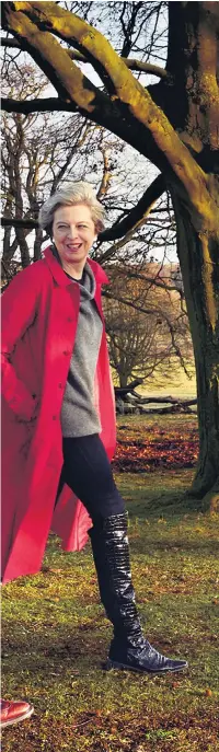  ??  ?? Theresa May with husband Philip at Chequers for the photo shoot with the American edition of Vogue, balancing her £450 red coat and £1200 cashmere jumper with an old pair of boots