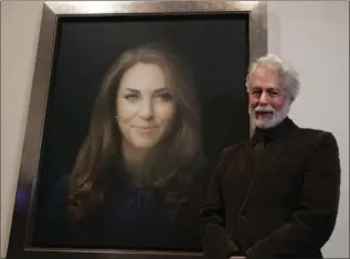  ?? SANG TAN, THE ASSOCIATED PRESS ?? Paul Emsley stands next to his portrait of the Duchess of Cambridge at the National Portrait Gallery in London.