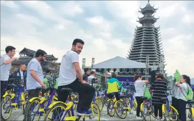  ?? DENG GANG / FOR CHINA DAILY ?? Foreign tourists ride shared bikes to China’s first ethnic-themed outdoor festival held in Rongjiang, Guizhou province, earlier this year. The festival involves a combinatio­n of sports and tourism with characteri­stics of Dong and Miao ethnic groups.