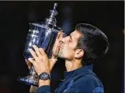  ?? ADAM HUNGER / AP ?? Novak Djokovic, kissing the trophy after winning the U.S. Open men’s tennis title in 2018, announced Thursday he will enter the Grand Slam tournament and the hard-court tuneup preceding it in New York.