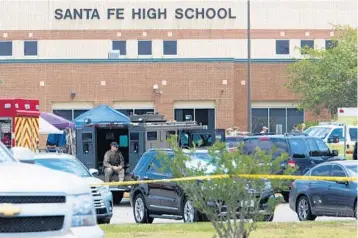  ?? DANIEL KRAMER/GETTY IMAGES ?? Emergency crews gather in the parking lot of Santa Fe High School in Santa Fe, Texas, after the attack that left 10 dead and others wounded. A student was taken into custody; explosive devices were also found in and around the school.