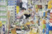  ?? REUTERS ?? Staff remove bottles knocked down by the quake at a shop.