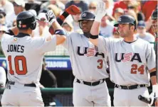  ?? Jeff Topping / Reuters 2006 ?? Ken Griffey Jr. (3) and Brian Schneider (24) greet Chipper Jones in 2006. That star-studded inaugural WBC team was eliminated in the second round.