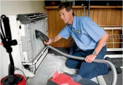  ??  ?? Rob Spink thoroughly cleans a heatpump in the course of a winter maintenanc­e check.