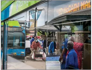  ?? (Arkansas Democrat-Gazette/Stephen Swofford) ?? People wait to board a bus that is being disinfecte­d Tuesday at the transit center in Little Rock. Transit agency ridership has plummeted amid the coronaviru­s crisis after increasing in 2019.