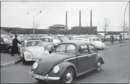  ?? THE ASSOCIATED PRESS FILE ?? Volkswagen workers drive their Beetle cars from the parking lot on their way home at the end of a days work at the world’s largest single auto plant, the Volkswagen factory (seen in background) in Wolfsburg, Germany.