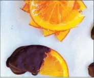  ??  ?? Oranges dipped in chocolate are a tasty appetizer.