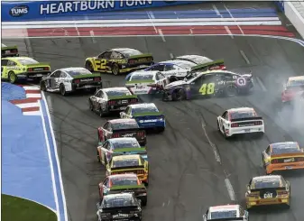  ?? MIKE MCCARN — THE ASSOCIATED PRESS ?? Jimmie Johnson (48) spins going into Turn 1 hitting the cars of Denny Hamlin (11) and Alex Bowman (88) during a NASCAR Cup Series auto race at Charlotte Motor Speedway, Sunday in Concord, N.C.