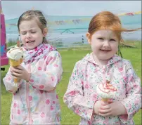  ?? f31 Arisaig games sisters13J­P ?? Sisters Freya and Cora Farelly, aged five and three, brave the weather and enjoy their ice creams.