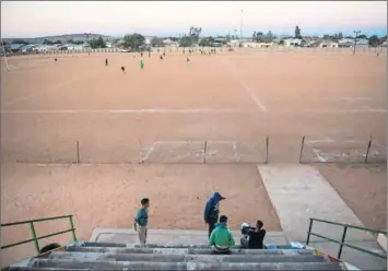  ??  ?? Way out: As dry and dusty as it is, Pofadder’s sports ground is well used (left). Sheep farms (above) surroundin­g the town provide limited employment.