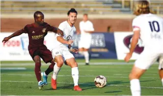  ?? STAFF PHOTO BY ROBIN RUDD ?? CFC’s Cameron Woodfin, center, passes to Juan Herandez (10) during Saturday’s match against Detroit City FC.