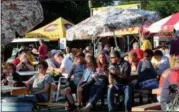  ?? JONATHAN TRESSLER — THE NEWS-HERALD ?? Visitors to the 58th annual Kirtland Kiwanis Strawberry Festival enjoy the various versions of festival food during the festival’s opening day June 15.