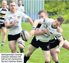  ??  ?? Nantgaredi­g’s George Gleeson releases the ball as he’s tackled by Bynea’s Nathan Baker.