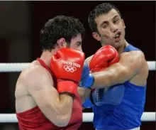  ?? Associated Press ?? Armenia’s Hovhannes Bachkov, left, lands a punch on Javid Chalabiyev of Azerbaijan Saturday in a men’s 63kilogram boxing match in Tokyo.