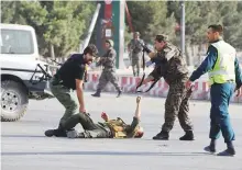  ?? Reuters ?? Security forces help an injured man at the site of a suicide bomb blast outside Kabul airport, yesterday.