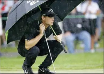  ?? TONY DEJAK — THE ASSOCIATED PRESS ?? Thomas Pieters waits to putt on the first green as rain falls during the second round of the Bridgeston­e Invitation­al at Firestone Country Club Friday in Akron, Ohio.