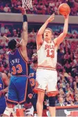  ?? BETH A. KEISER/ASSOCIATED PRESS ?? Chicago Bulls center and University of New Mexico alumnus Luc Longley shoots over New York’s Patrick Ewing during playoff action on May 14, 1996.